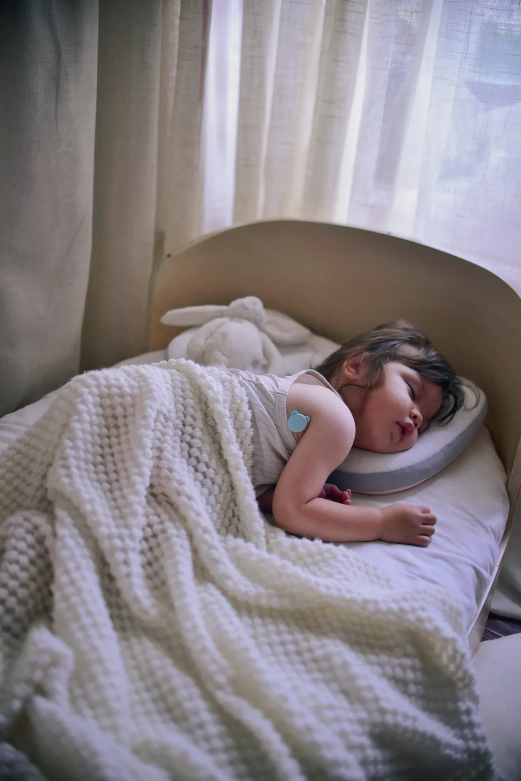 Baby sleeping undisturbed while wearing the OnCorva continuous fever monitor